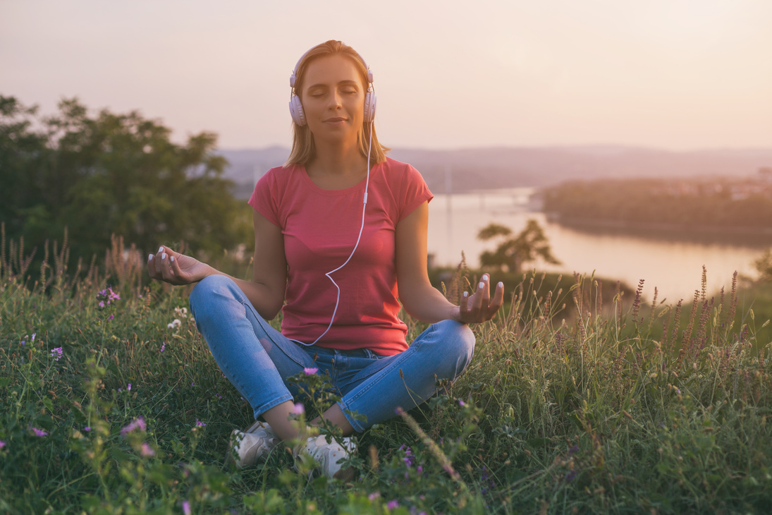 Woman enjoys meditating and listening music